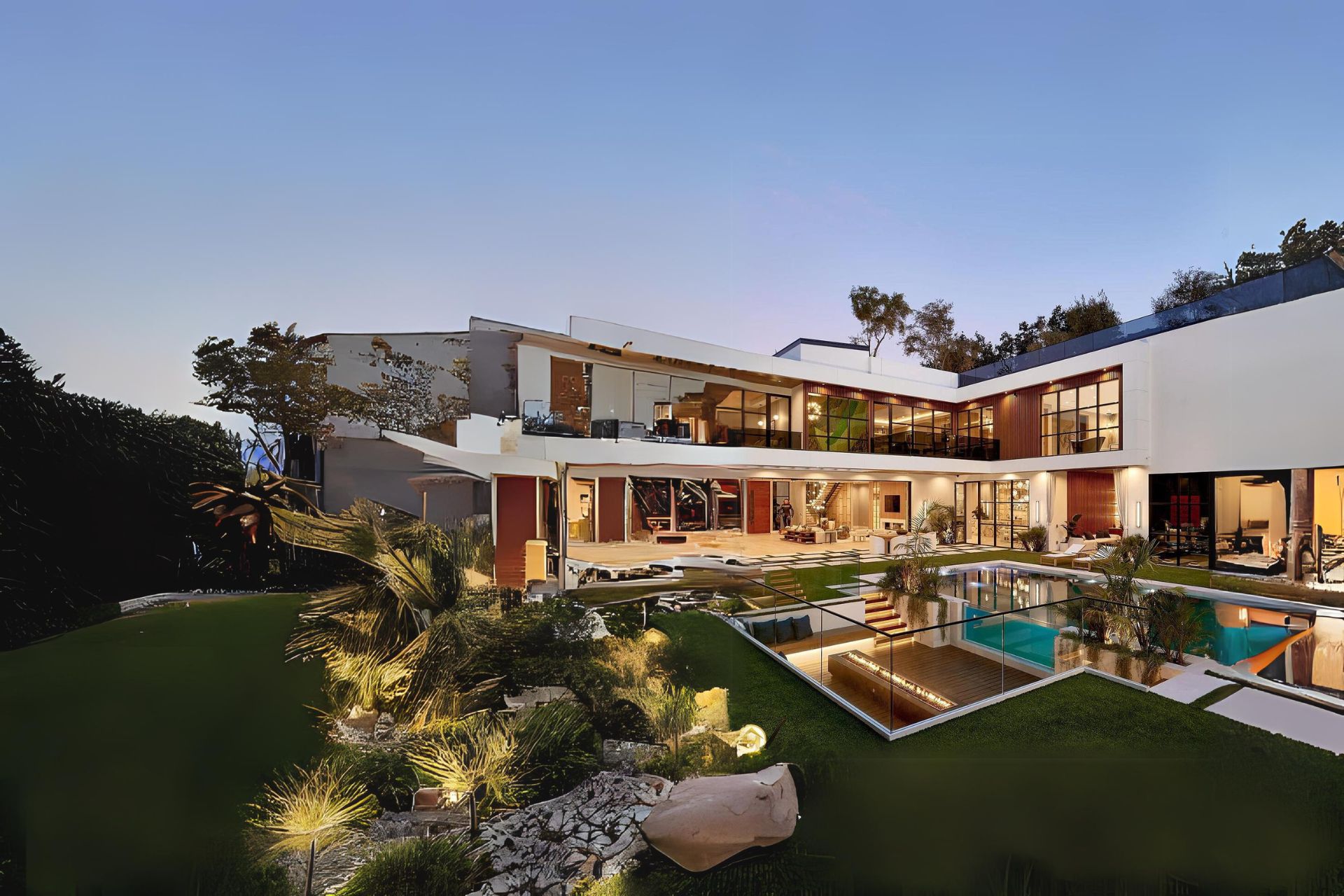 A contemporary luxury villa with illuminated living spaces and a private pool
